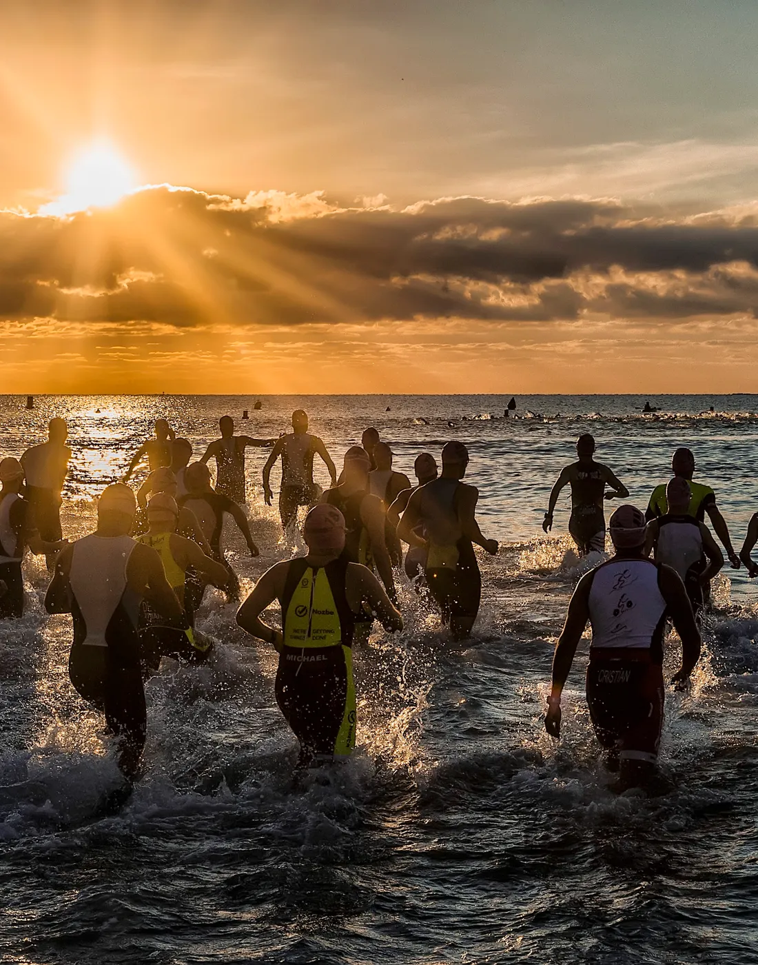 Nadadores entrando al mar al amanecer en la costa de Alicante
