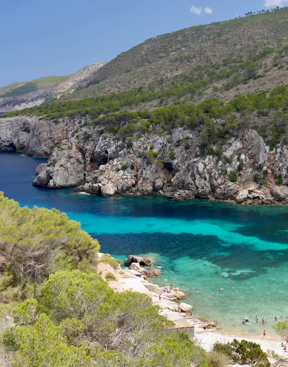 Cala de aguas turquesa y costa rocosa en Ibiza