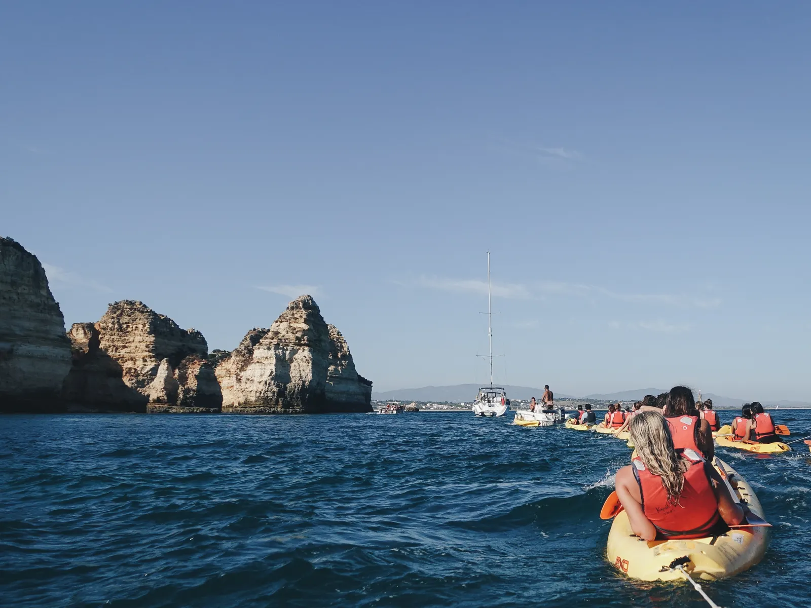 Kayaks de apoyo acompañando en el agua junto a la costa